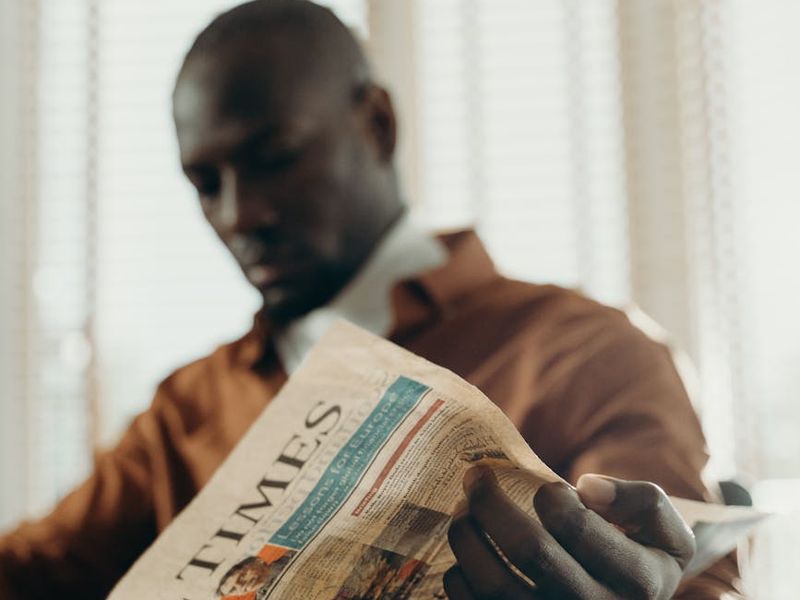 Person sitting comfortably near a window with soft light.